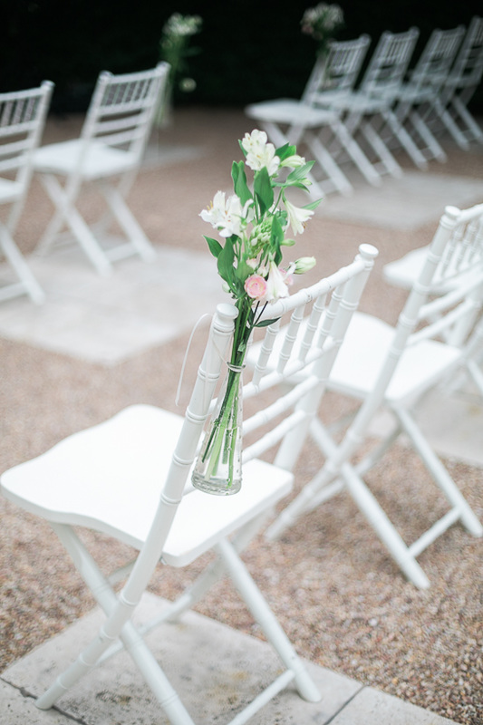 Weißer Stuhl mit Blumen-Hochzeitsdekoration