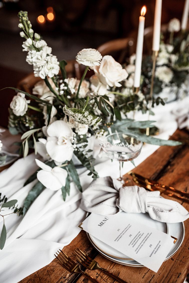 Tischdekoration mit frischen Blumen und Menükarte