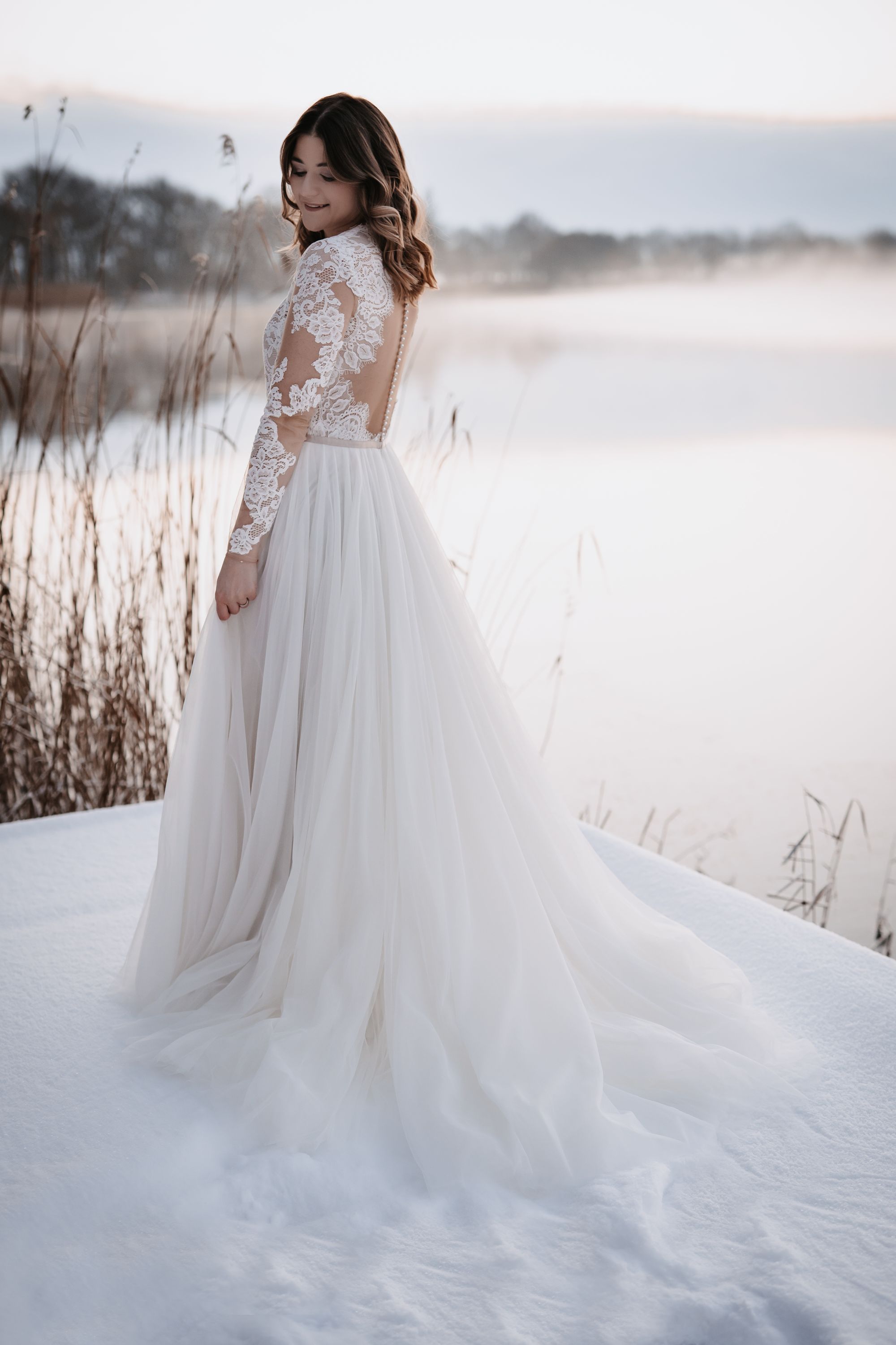Braut in schickem Brautkleid mit langen Spitzenärmeln