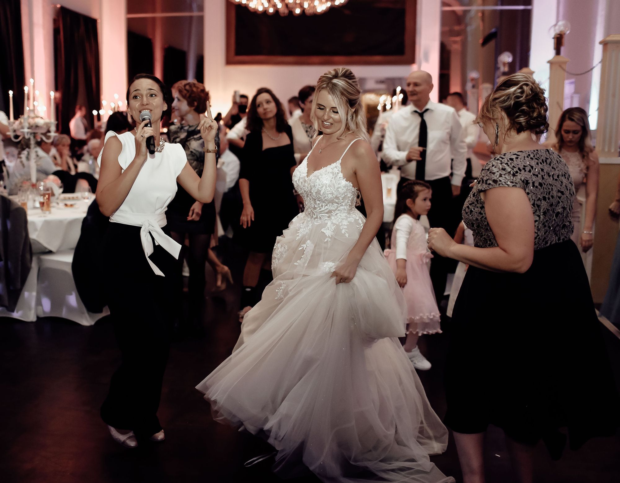 Brautpaar tanzt mit Hochzeitsmoderatorin