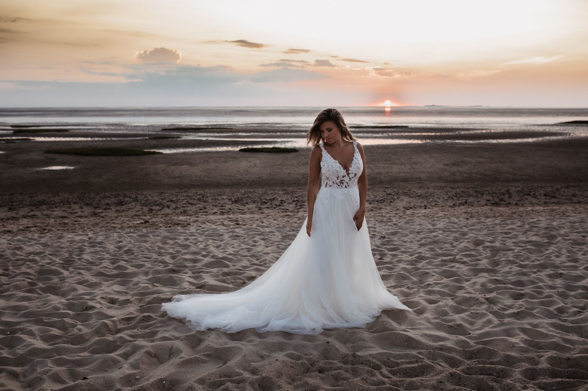 Eine Braut steht am Strand