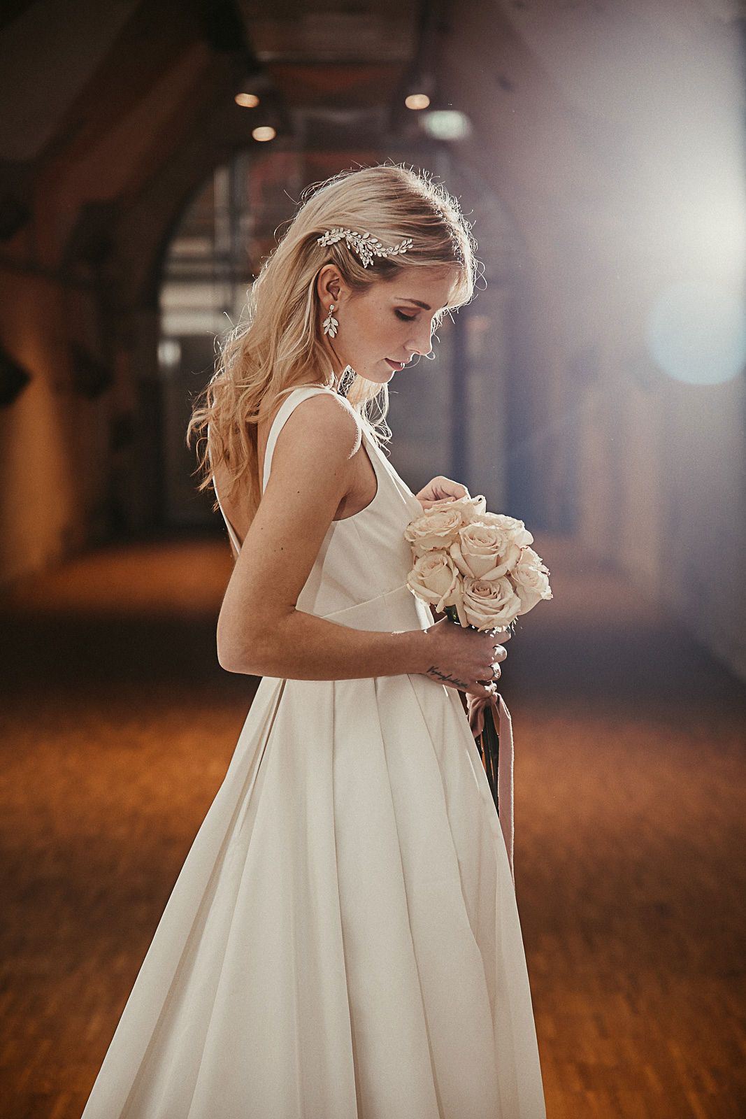 Braut mit Empire Brautkleid um Blumenstrauß