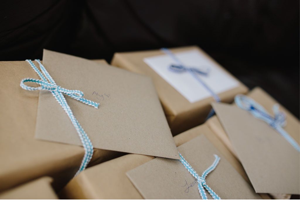 mehrere verpackte Gastgeschenke mit personalisierten Briefen am hochzeitstag