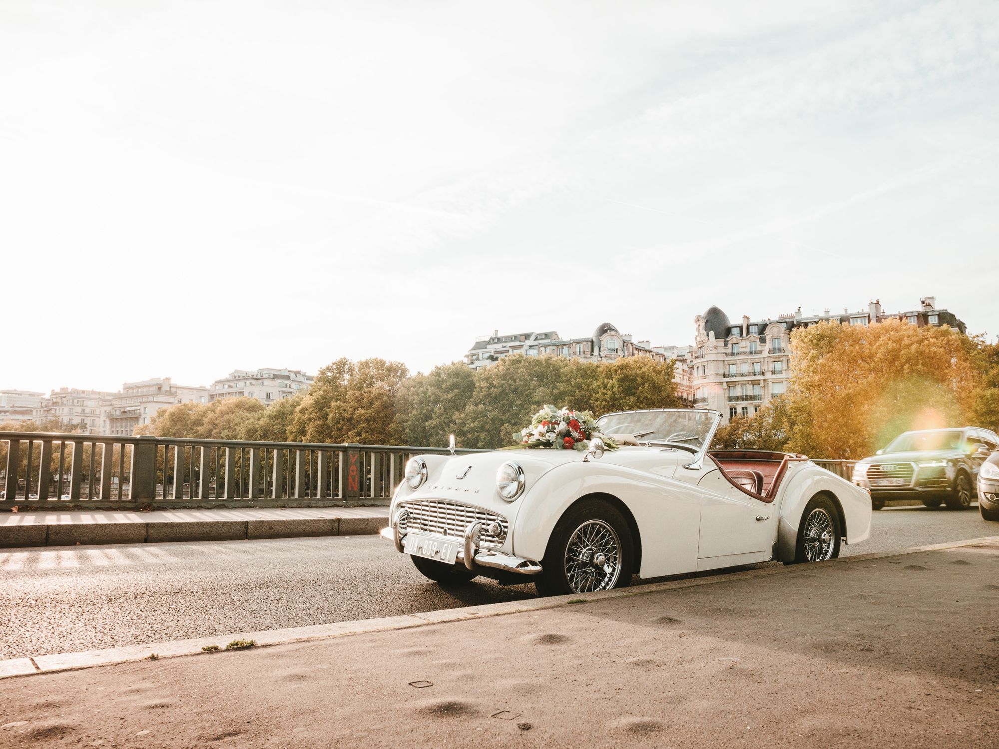 Ein Hochzeitsauto mit Autodeko steht auf einer Brücke