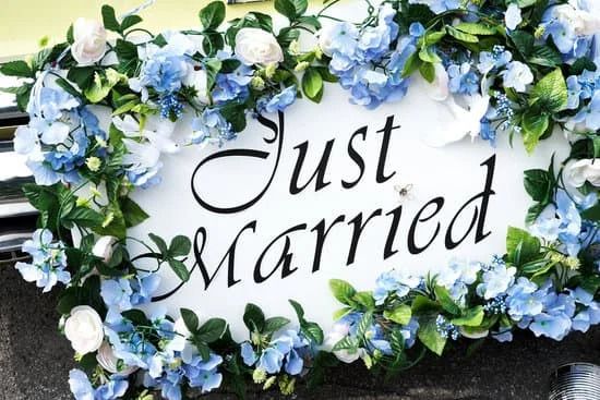 Ein "Just Married" Schild ist mit Blumen geschmückt