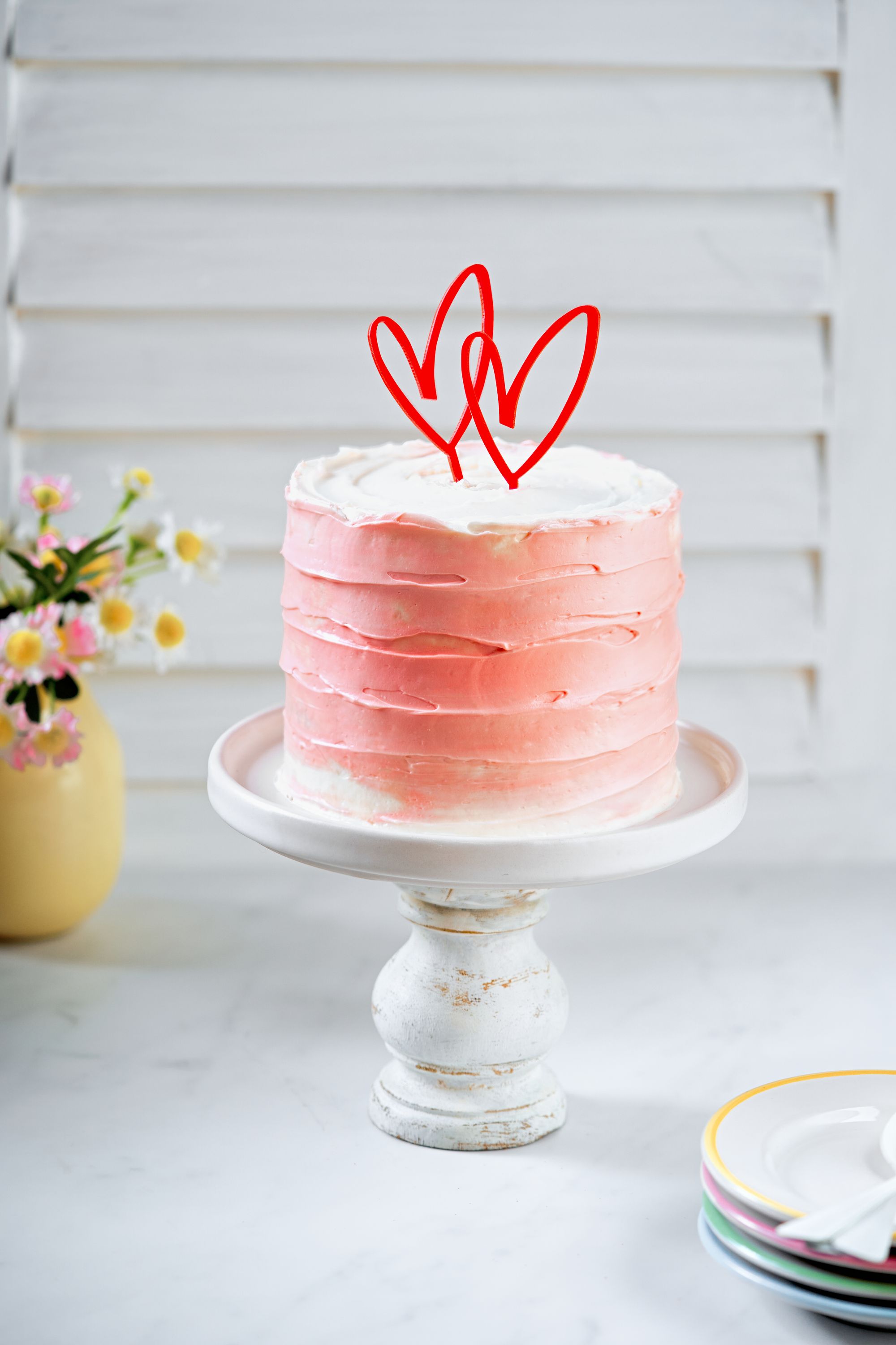 Zwei rote Herzen sind auf eine Torte gesteckt