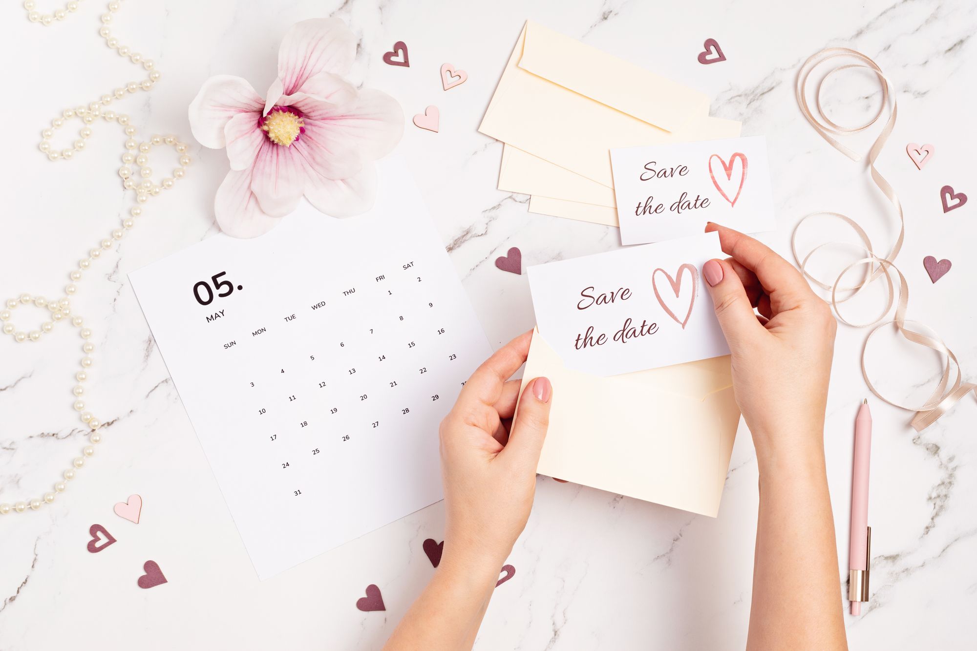 Hände die Save the Date Einladungen verpacken