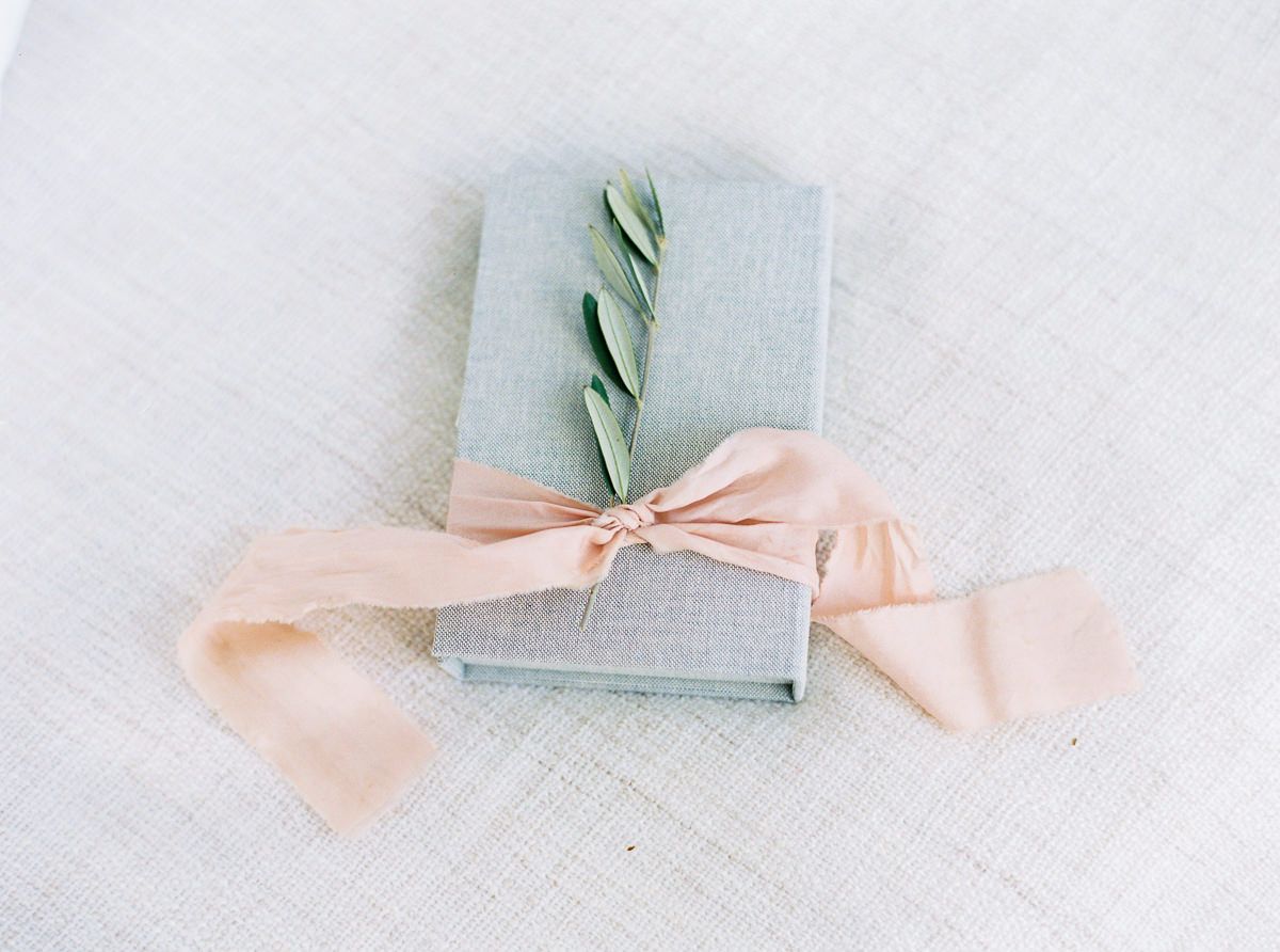 Hochzeitskarte schreiben: Buch dekoriert mit Schleife und Olivenzweig
