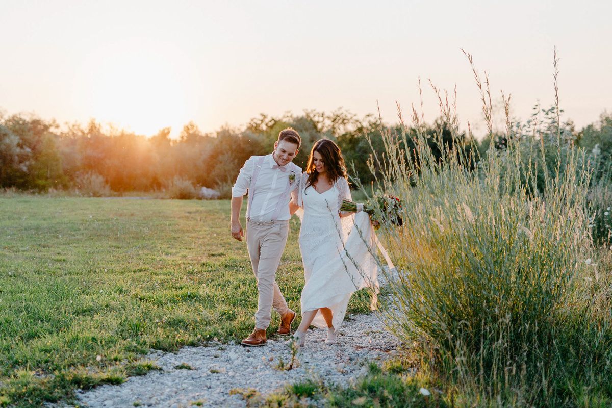 Sommerhochzeit: Brautpaar läuft über eine Wiese