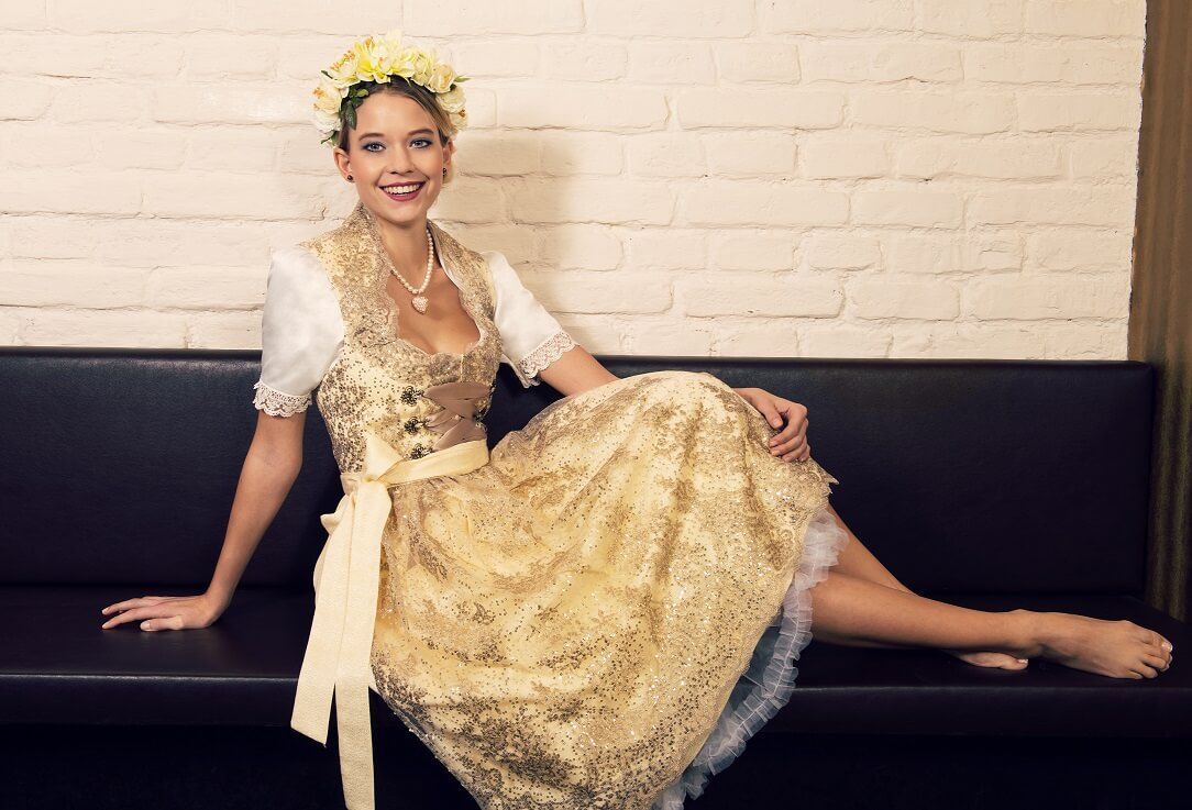 goldenes Dirndl mit weißer Bluse und Spitze
