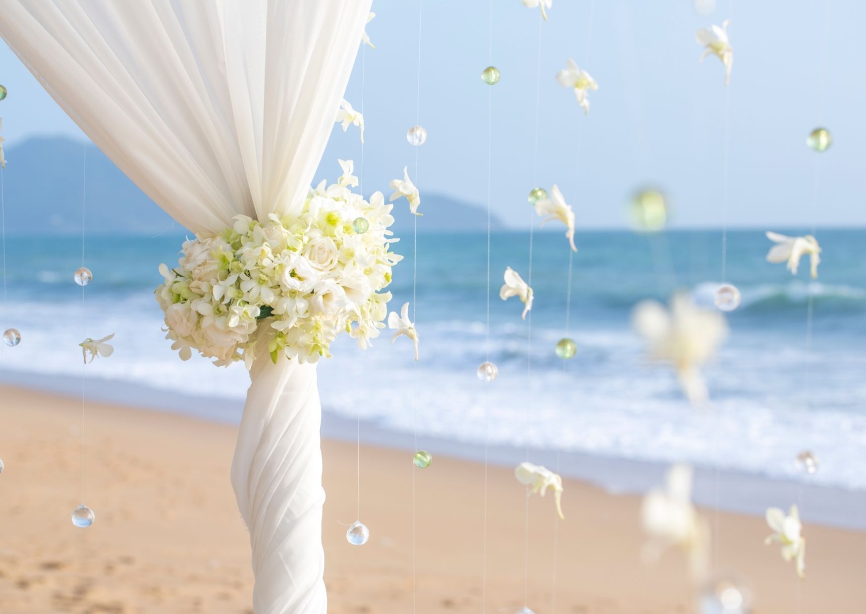 Die Blumendeko passt zur Strandhochzeit