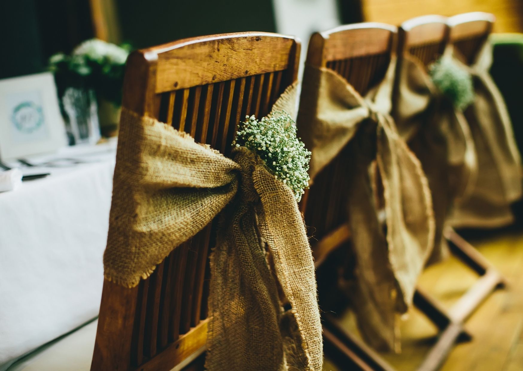 Rustikale Elemente am Tisch und an den Stühlen bei der Hochzeit