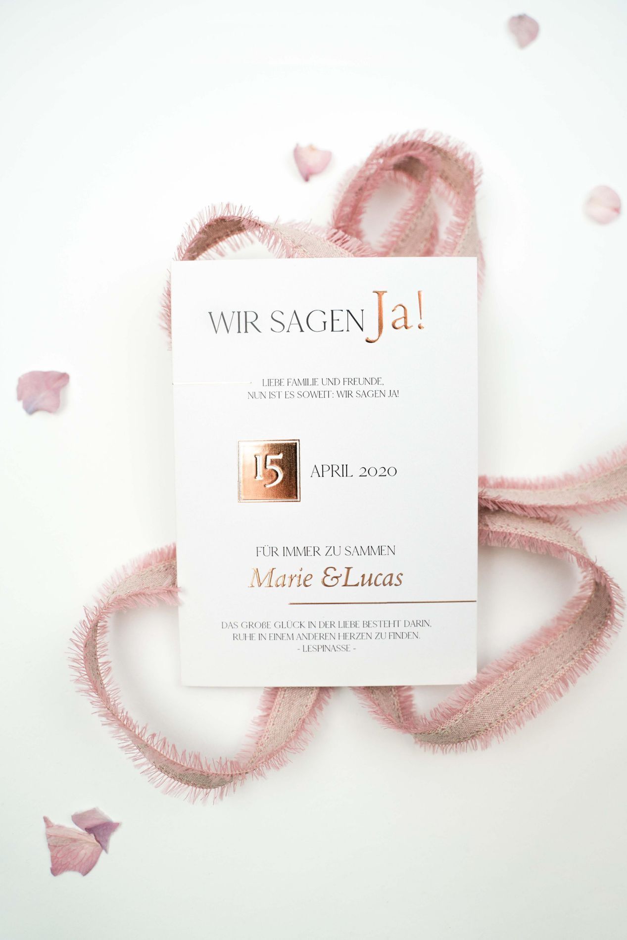 Hochzeitseinladung auf weißem Hintergrund mit rosa Band