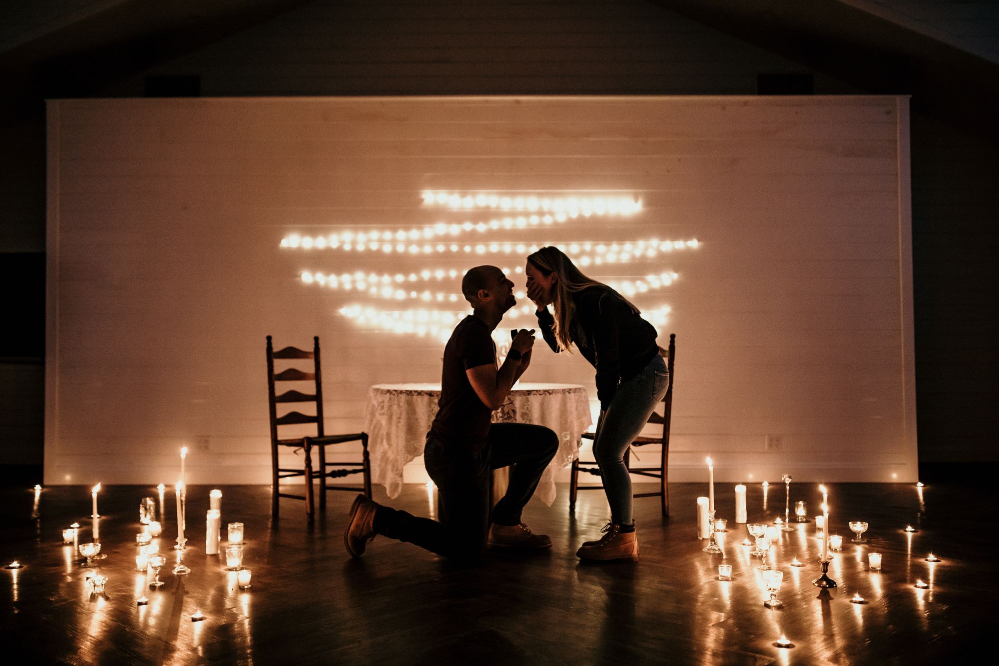 Romantischer Heiratsantrag mit Kerzen und Lichterketten