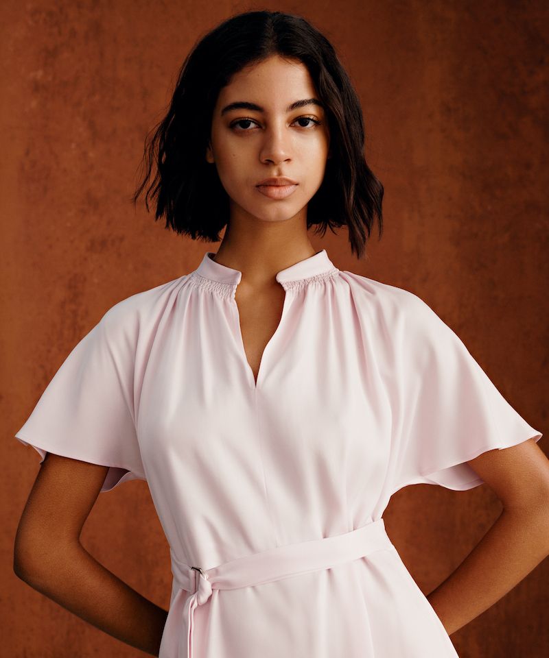 Wunderschöne junge Frau in rosa Kleid