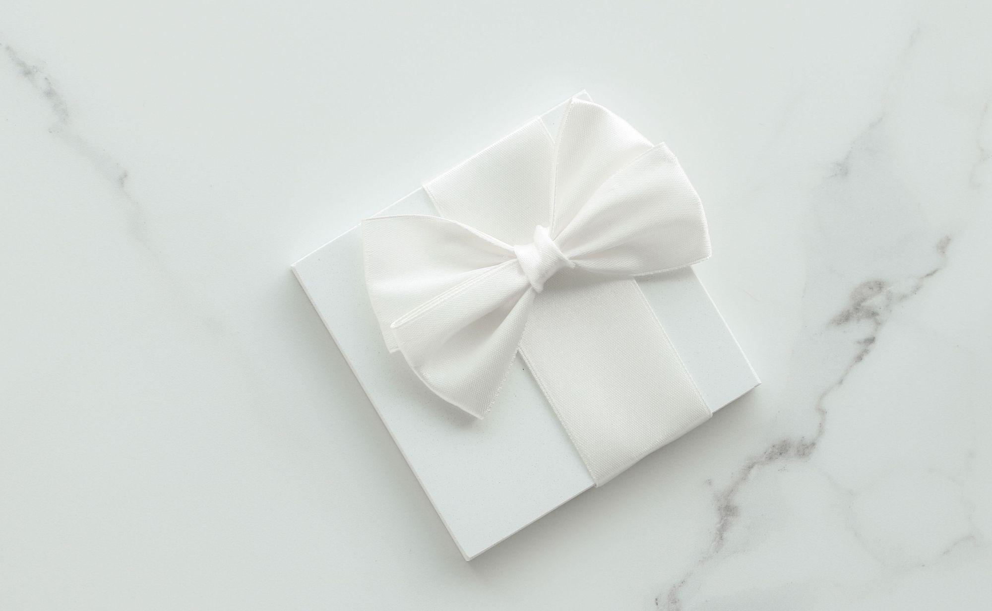 Geschenk mit weißer Schleife