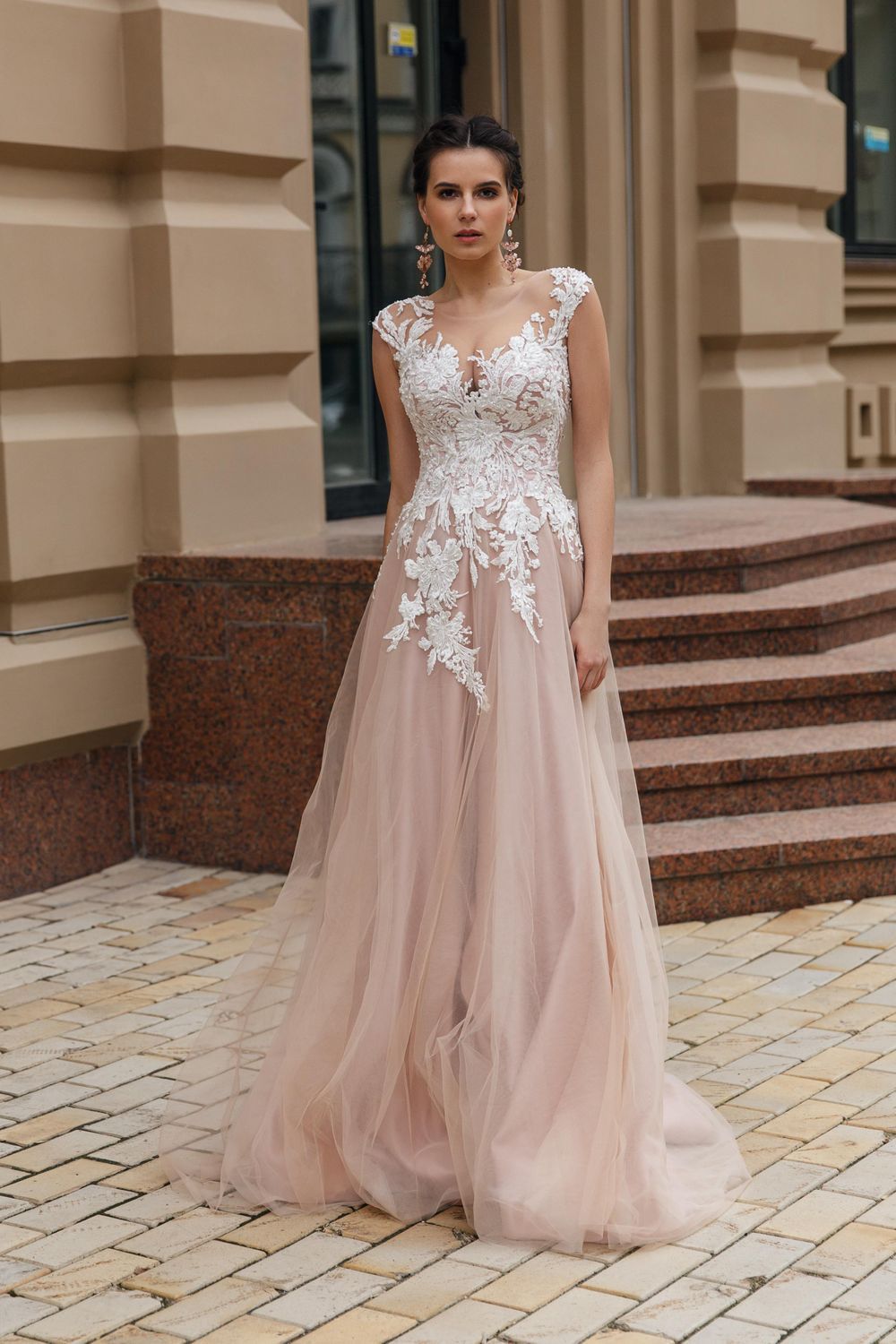 Die Braut trägt ein Hochzeitskleid, das aus rosafarbenen Tüll besteht.