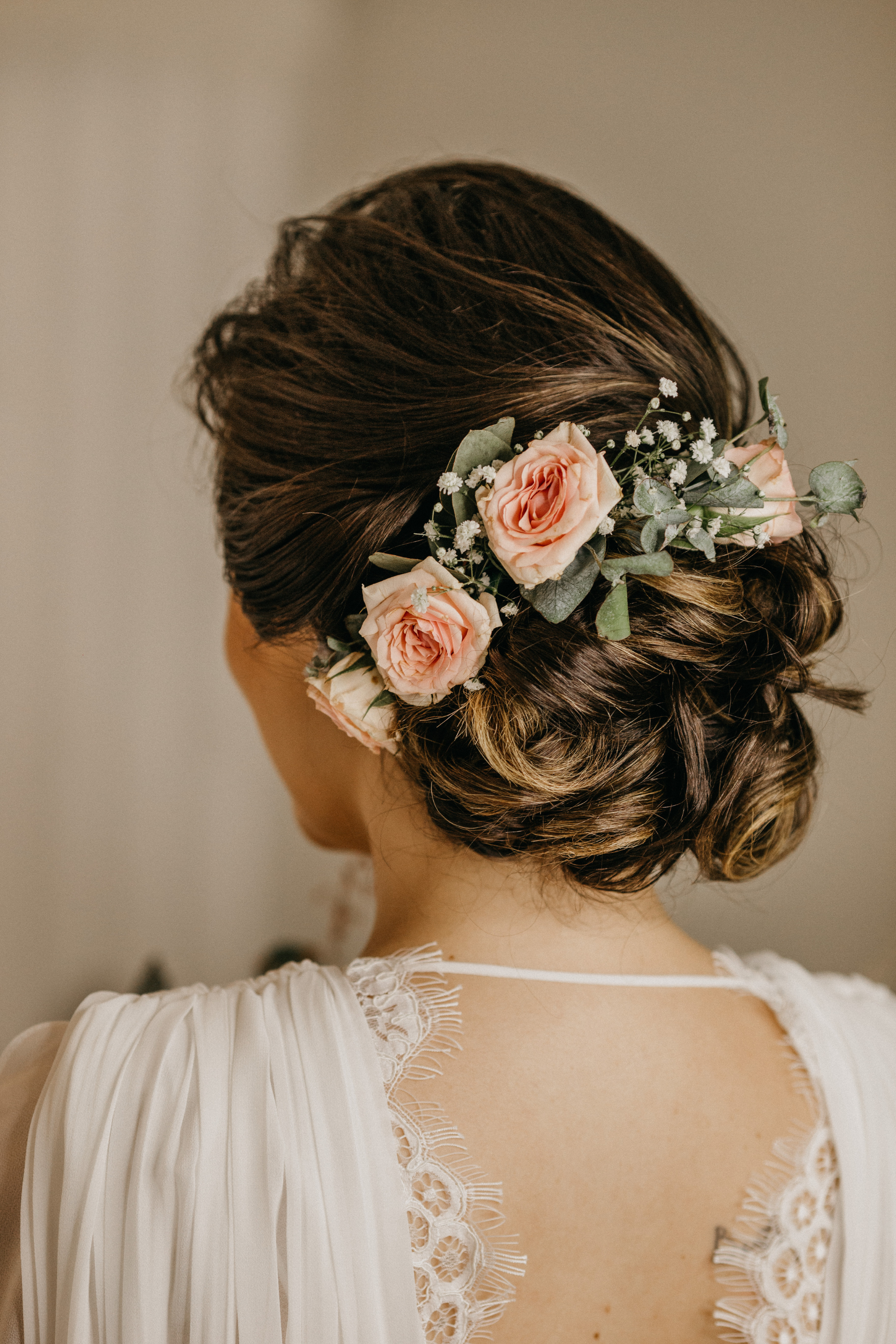 Die Braut trägt eine Hochsteckfrisur mit Haarschmuck.