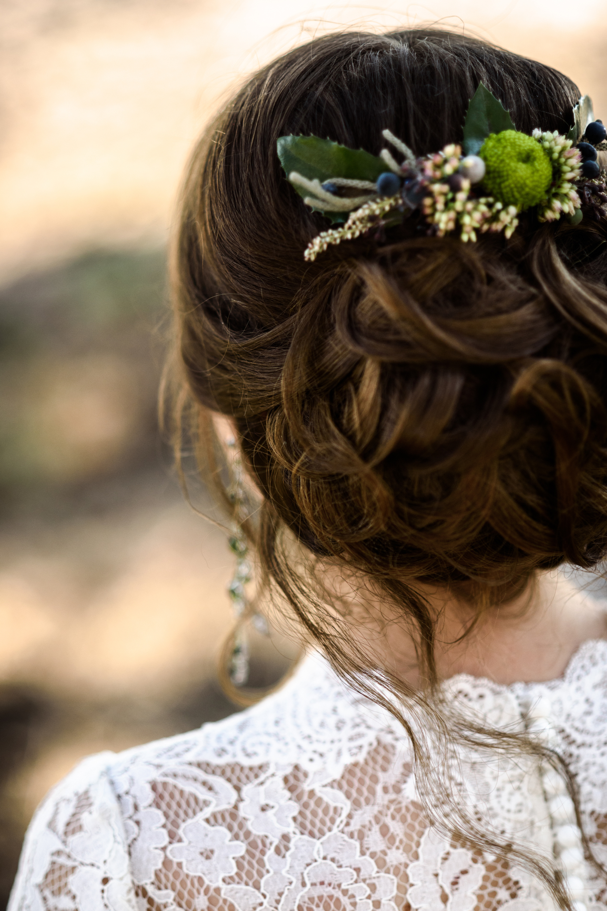 Die Braut trägt eine lockere Hochsteckfrisur mit Haarschmuck.