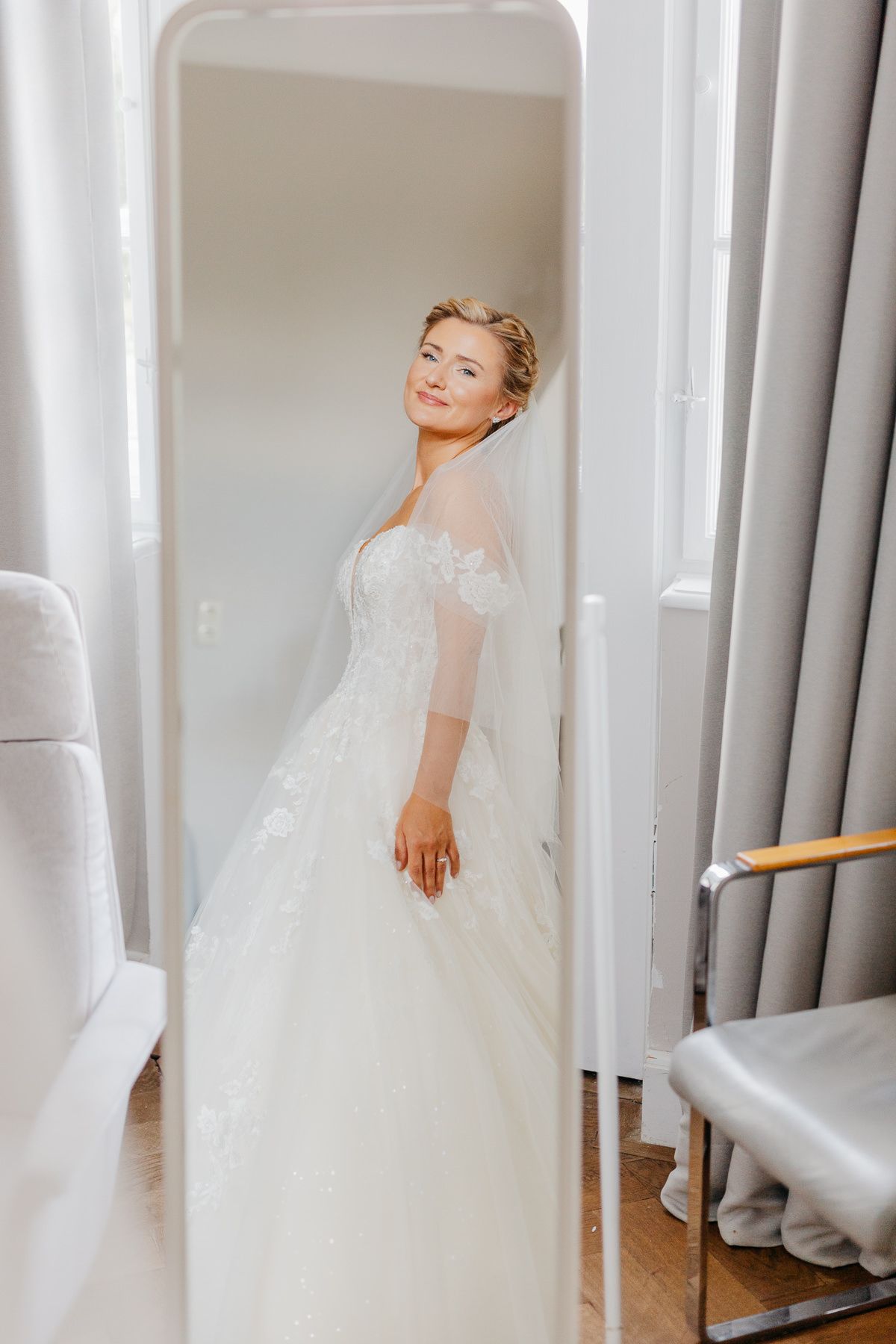 Die Braut sieht sich vor der Hochzeit im Spiegel an.