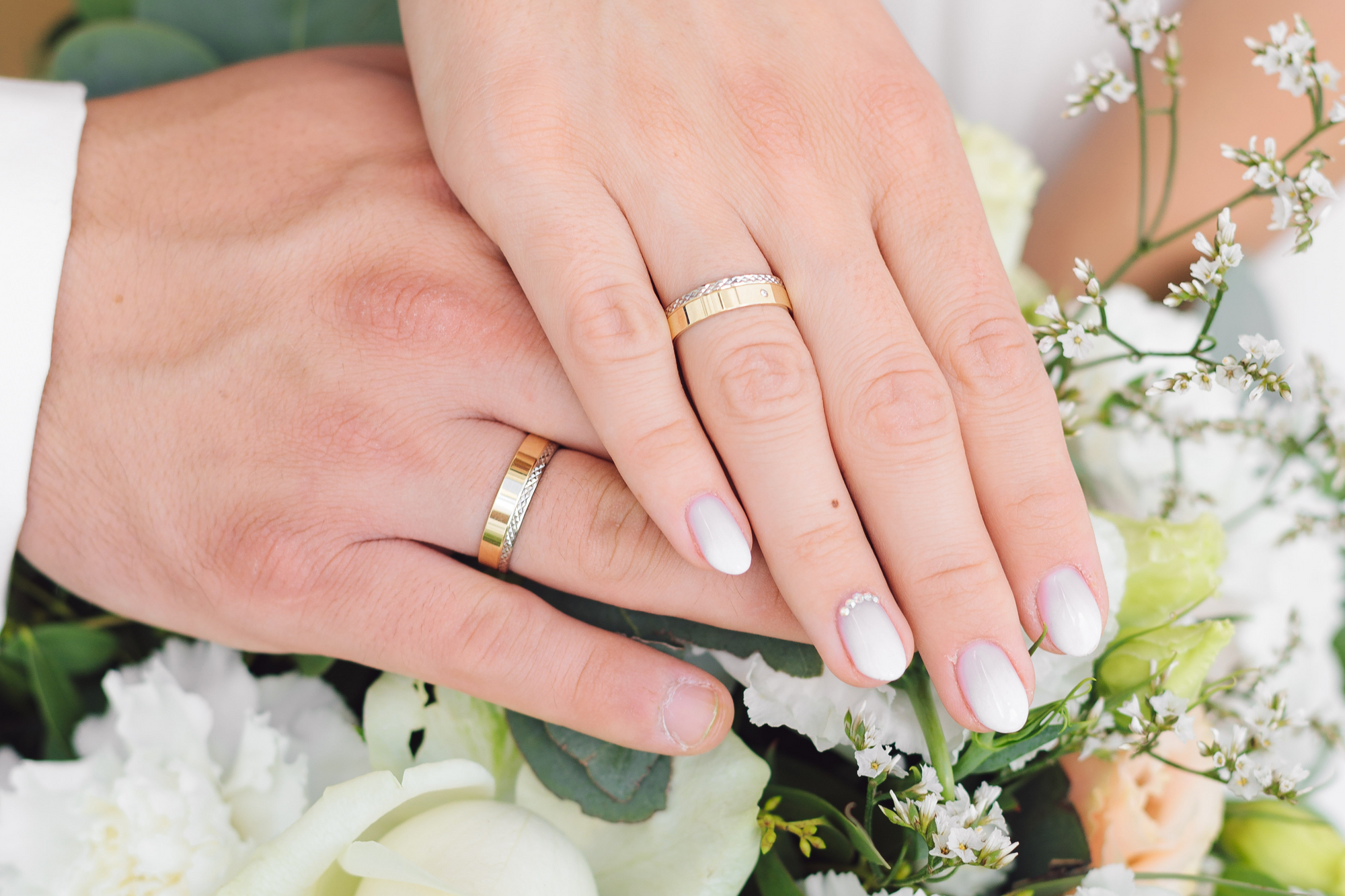 Die Braut hat Glitzersteine auf dem Nagel ihres Ringfingers.