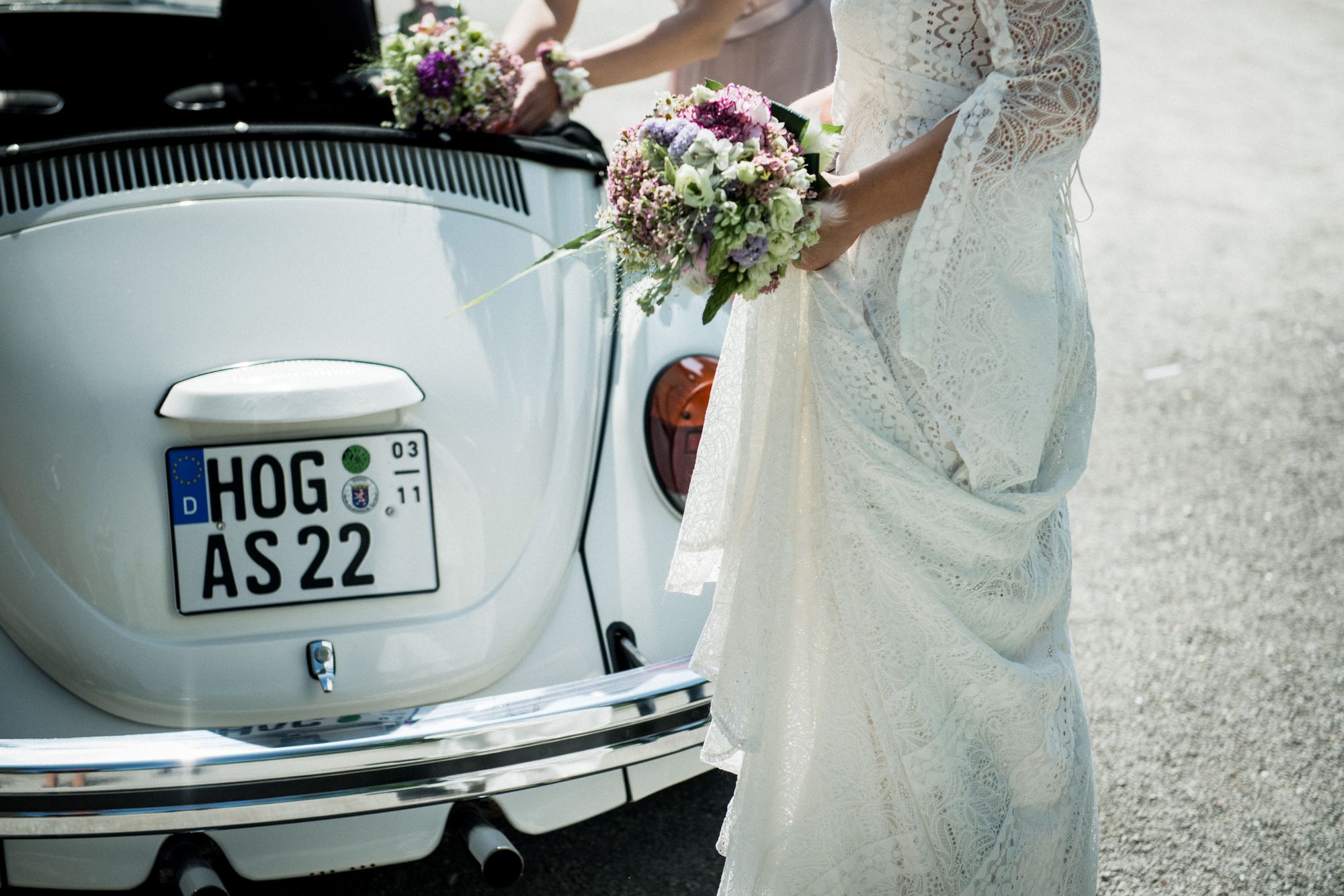 Das Hochzeitsauto wird mit Blumen geschmückt, die farblich zu dem Brautstrauß passen.