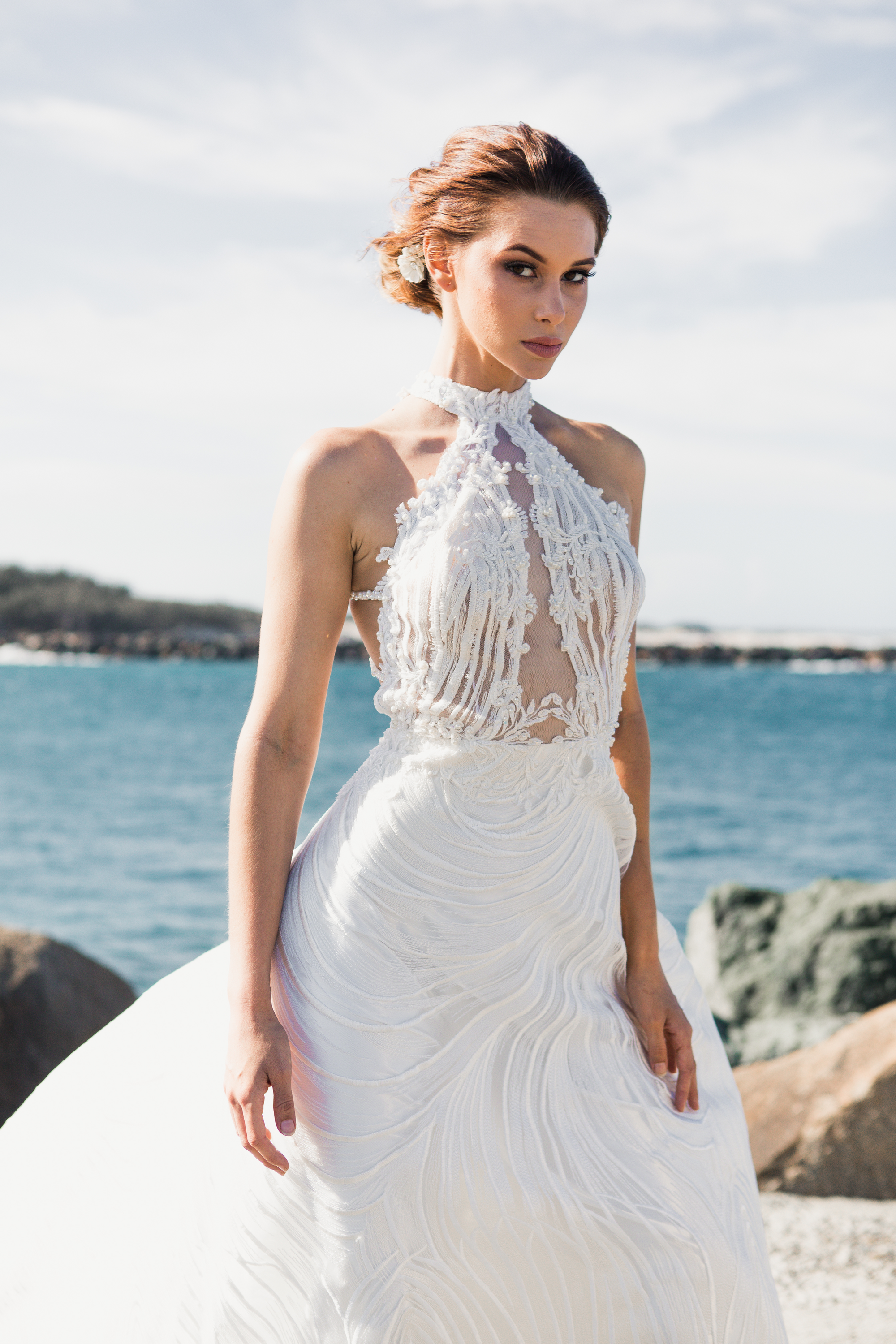 Die Braut trägt ein Neckholder Brautkleid und dazu eine Hochsteckfrisur.