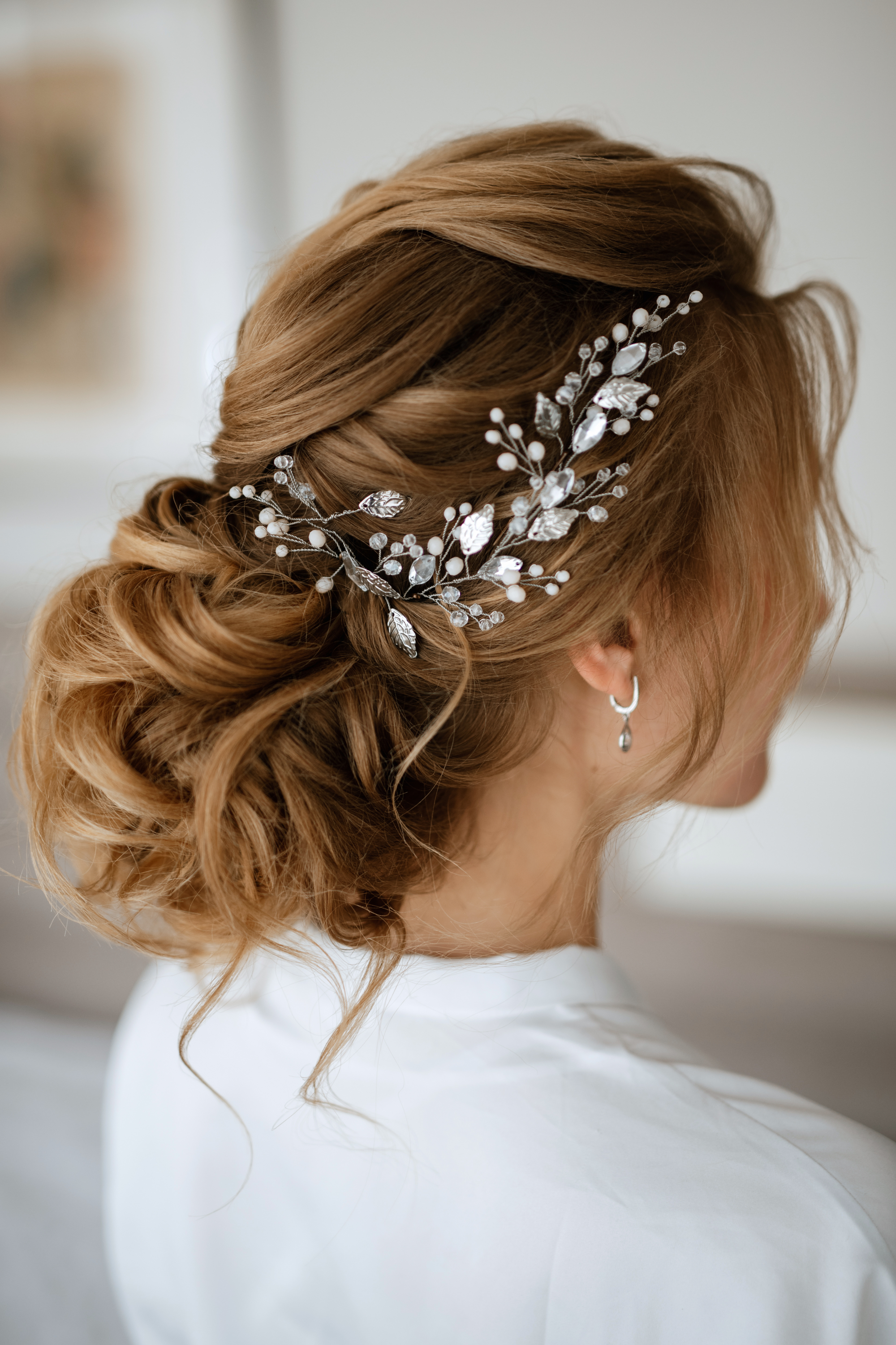 Die Braut trägt eine Hochsteckfrisur mit Locken.