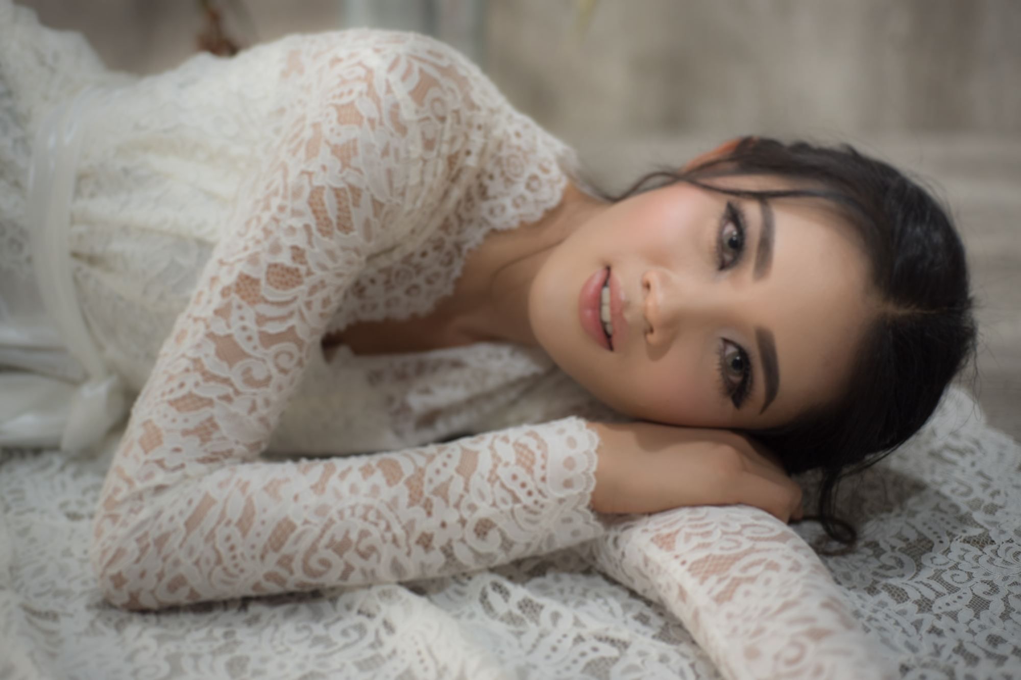 Die Braut trägt ein Hochzeitskleid mit langen Ärmeln und dazu eine gesteckte Nackenvariation.