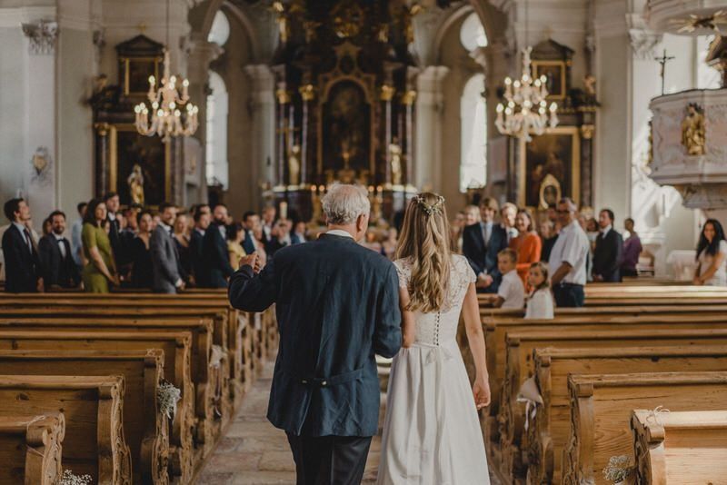 Die Braut wird von ihrem Vater zum Altar geführt.