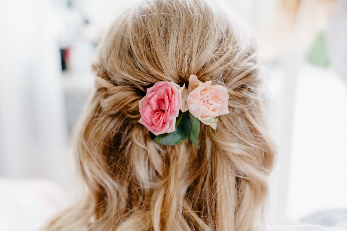 Die Braut trägt eine offene Brautfrisur mit Blumen.
