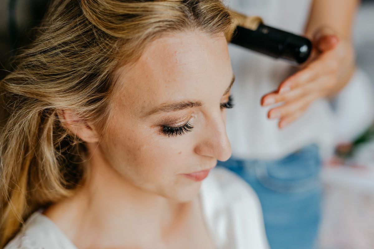 Die Braut wird von ihrer Stylistin gestylt.