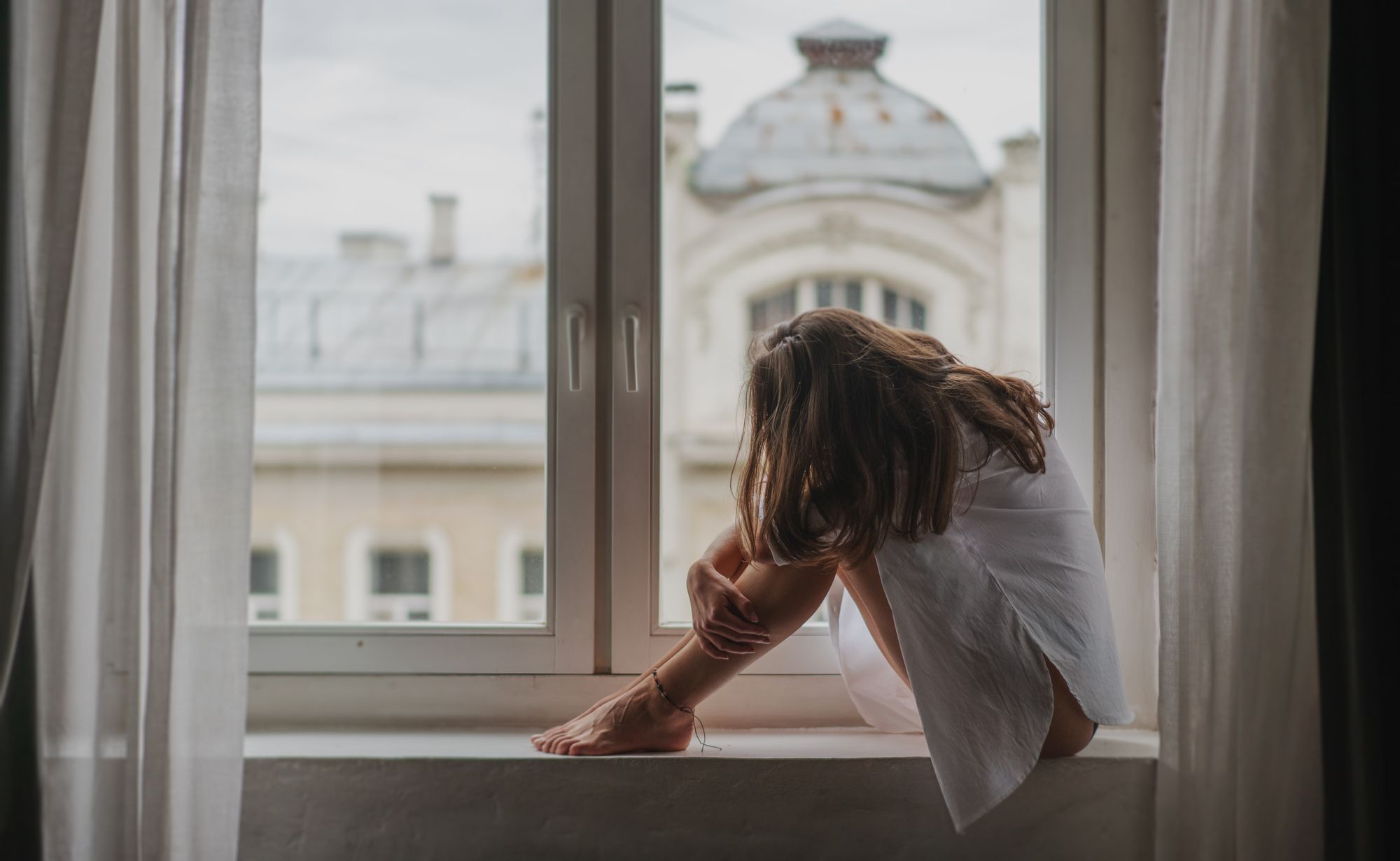 Wahre Liebe verursacht große Emotionen: Trauernde Frau am Fenster